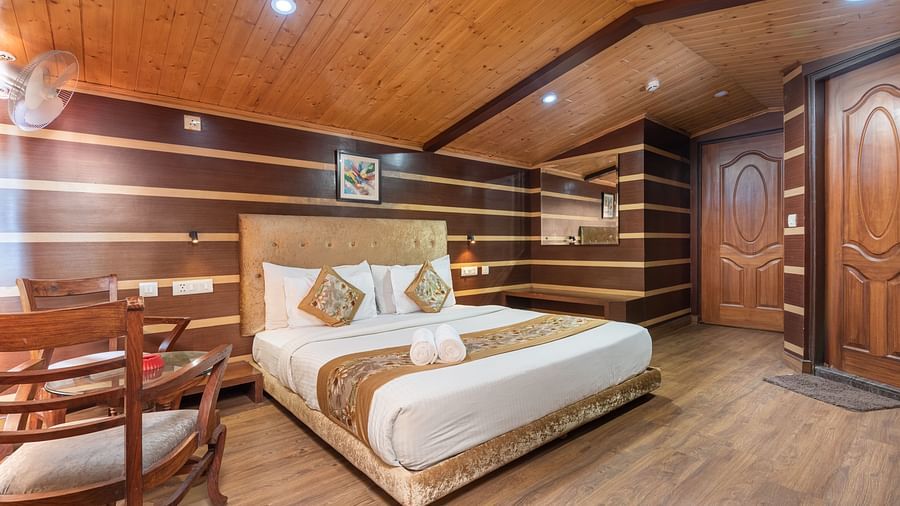 Super Deluxe Room with a king size bed and wooden finished flooring at DLS Hotels The Rock Castle.